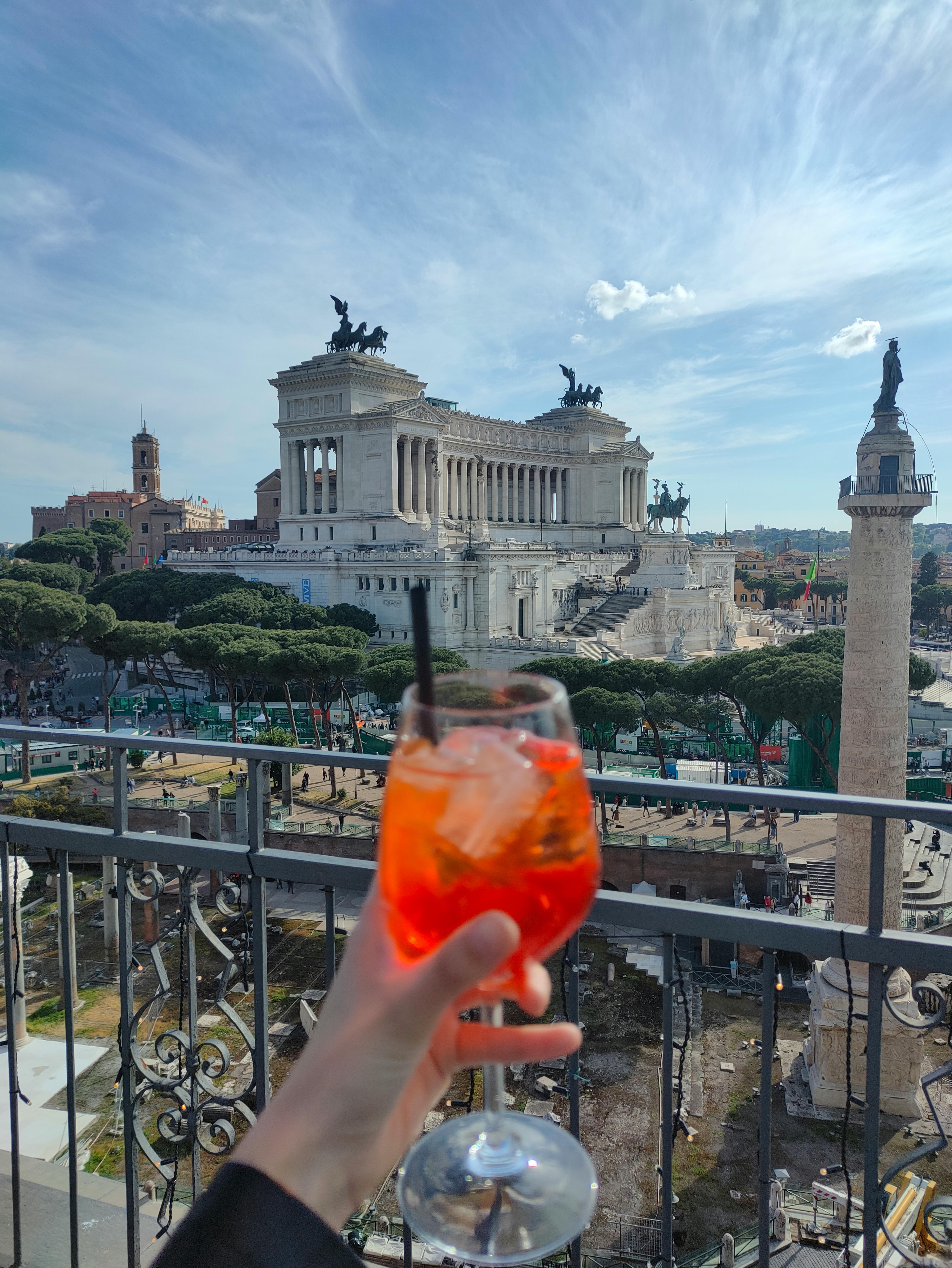 Aperol Spritz cocktail with a view of the Vittoriano monument in Rome