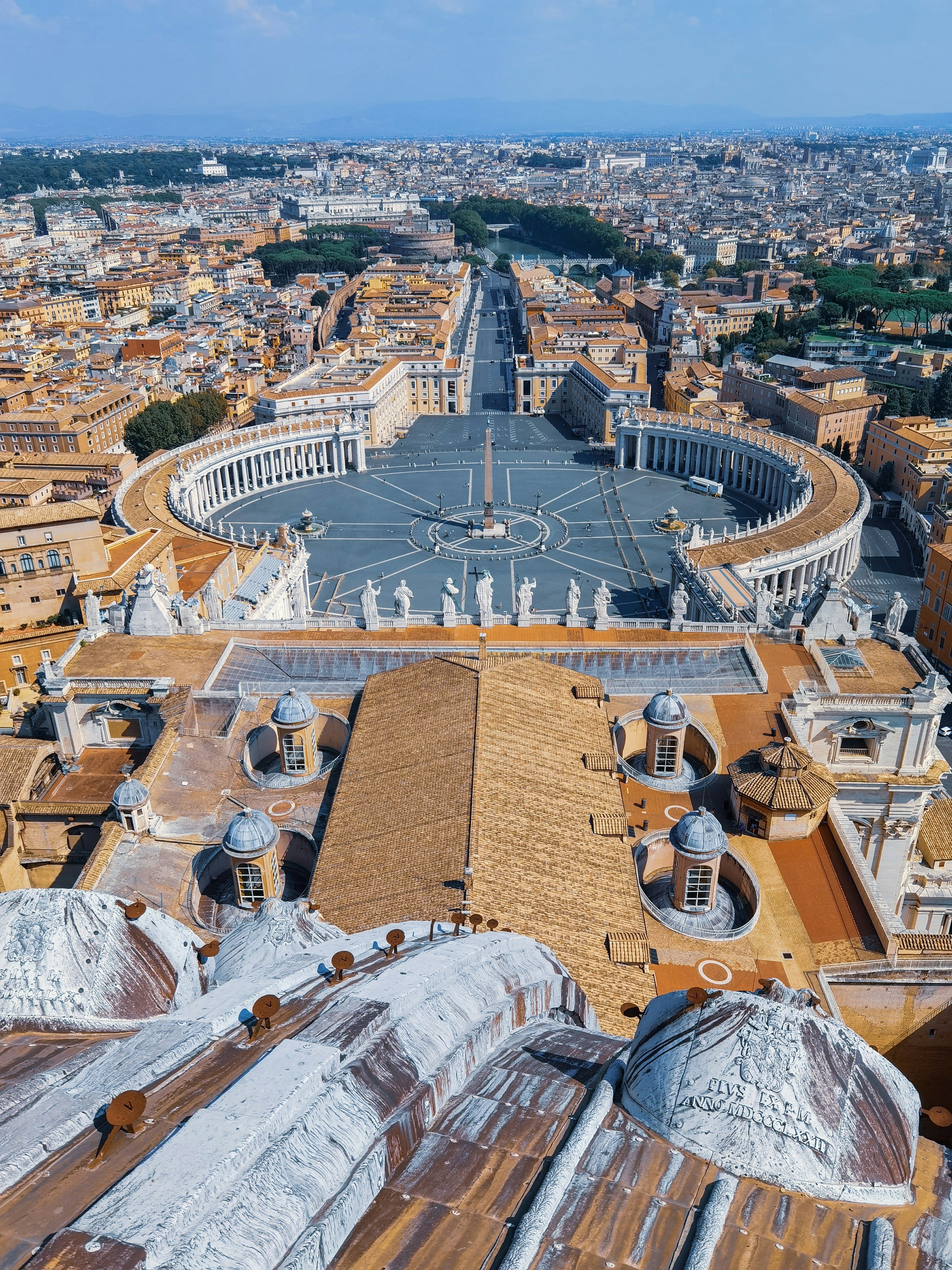 Aerial view of St. Peter's Square in Vatican City with the iconic colonnade and Rome cityscape